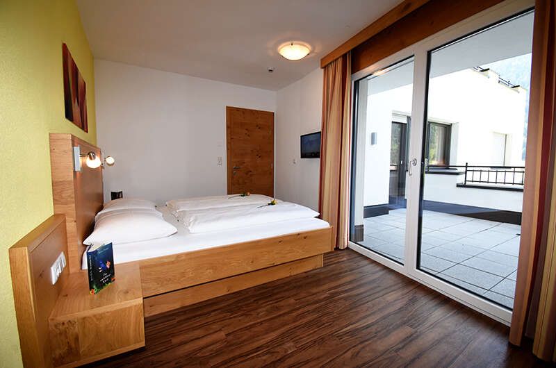 Schlafzimmer mit Balkon im Appartement Top 4 im Chalet Barbara
